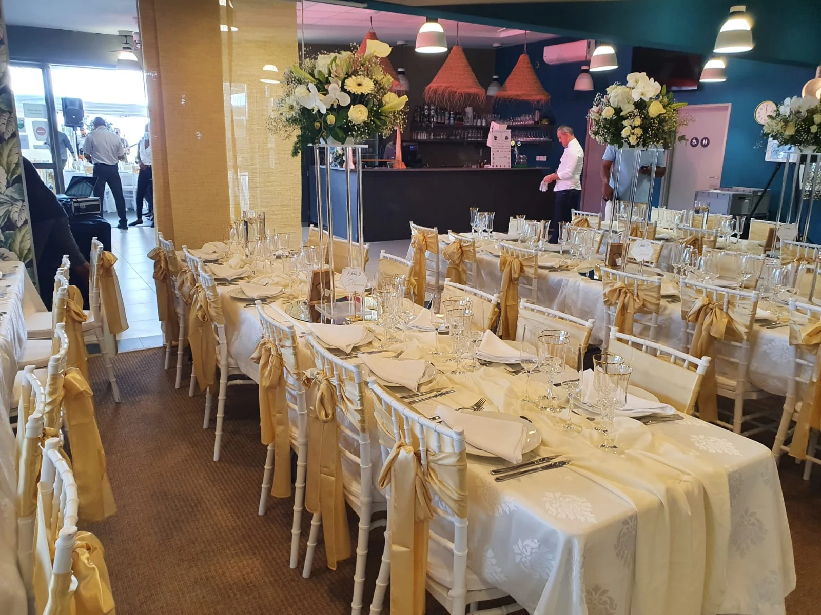 Tables de réception avec chaises blanches et décoration dorée