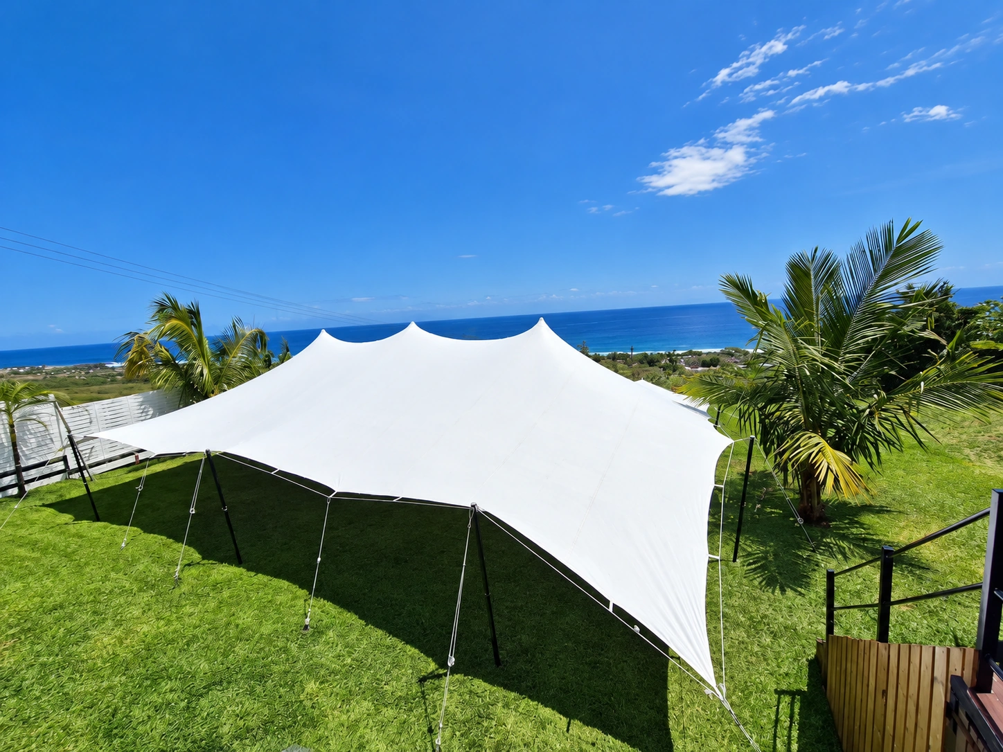 Tente nomade blanche Réuni’tente installée dans un jardin avec vue sur l’océan à La Réunion